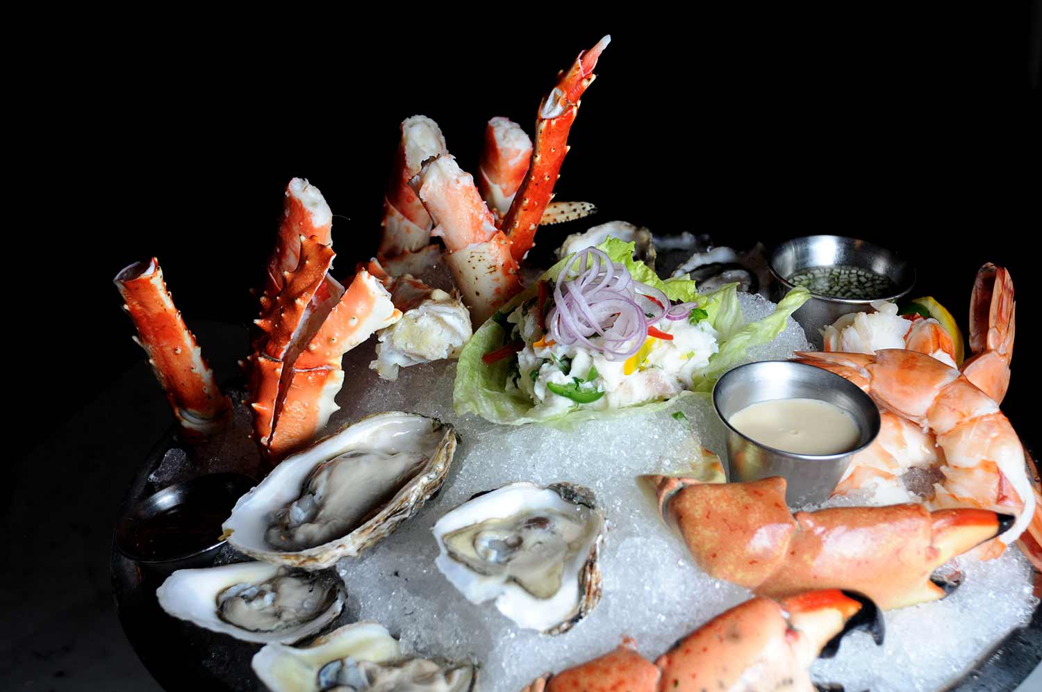 Chilled seafood platter with king crab, oysters, shrimp, and lobster on crushed ice
