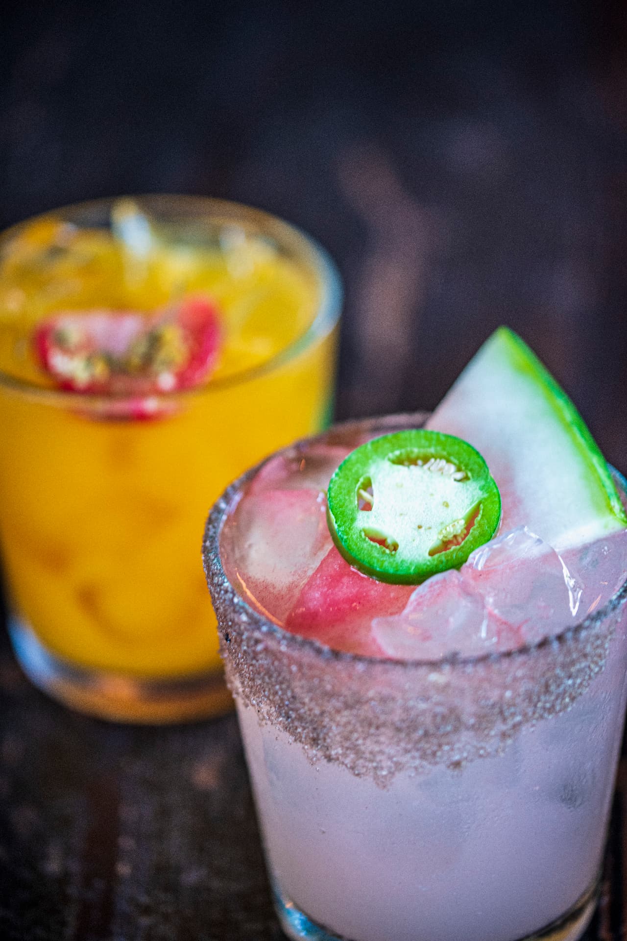 Two El Camino cocktails — a watermelon jalapeño margarita and a passion fruit drink