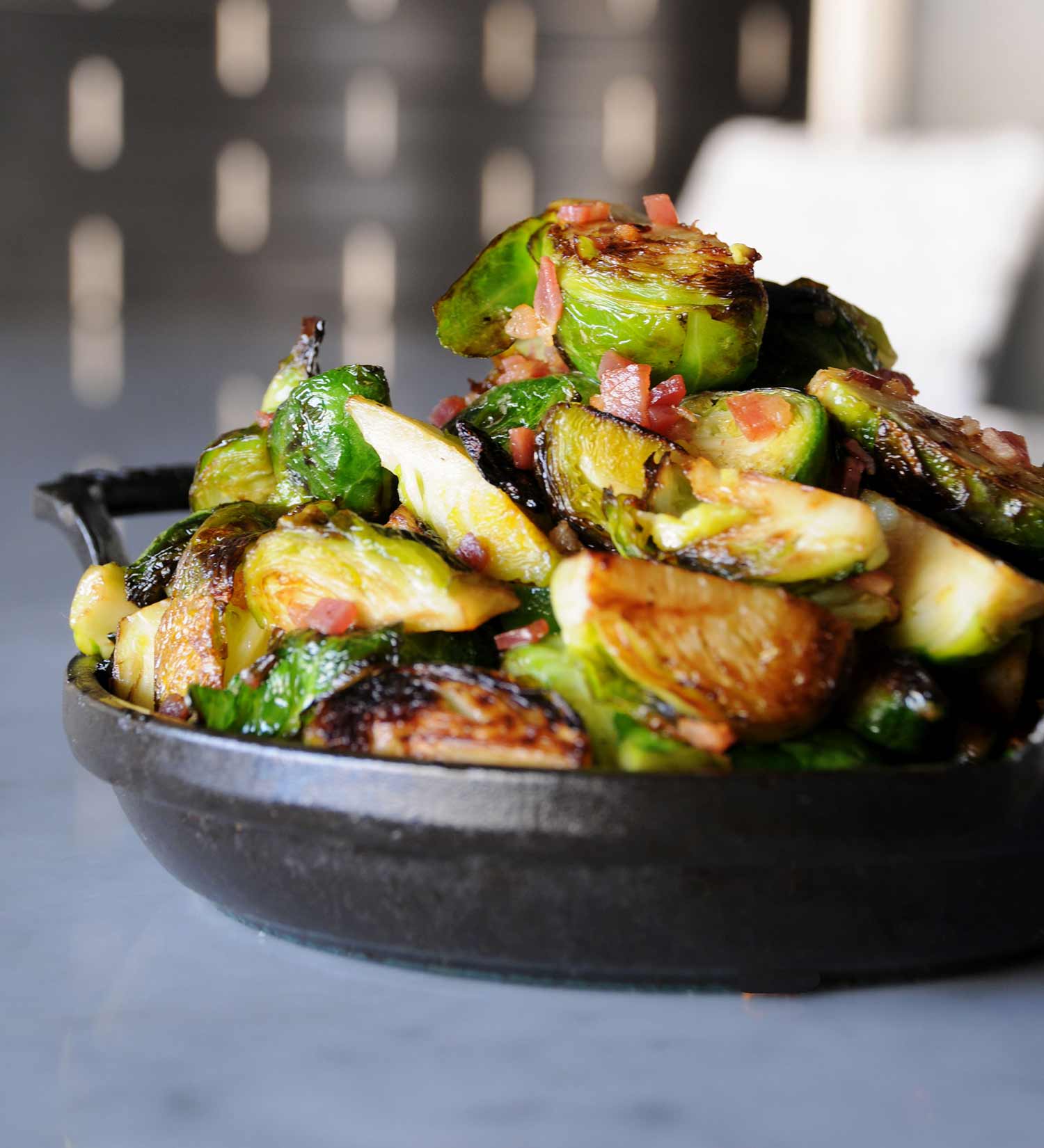 Crispy Brussels sprouts with bacon served in a cast-iron pan at CUT 432